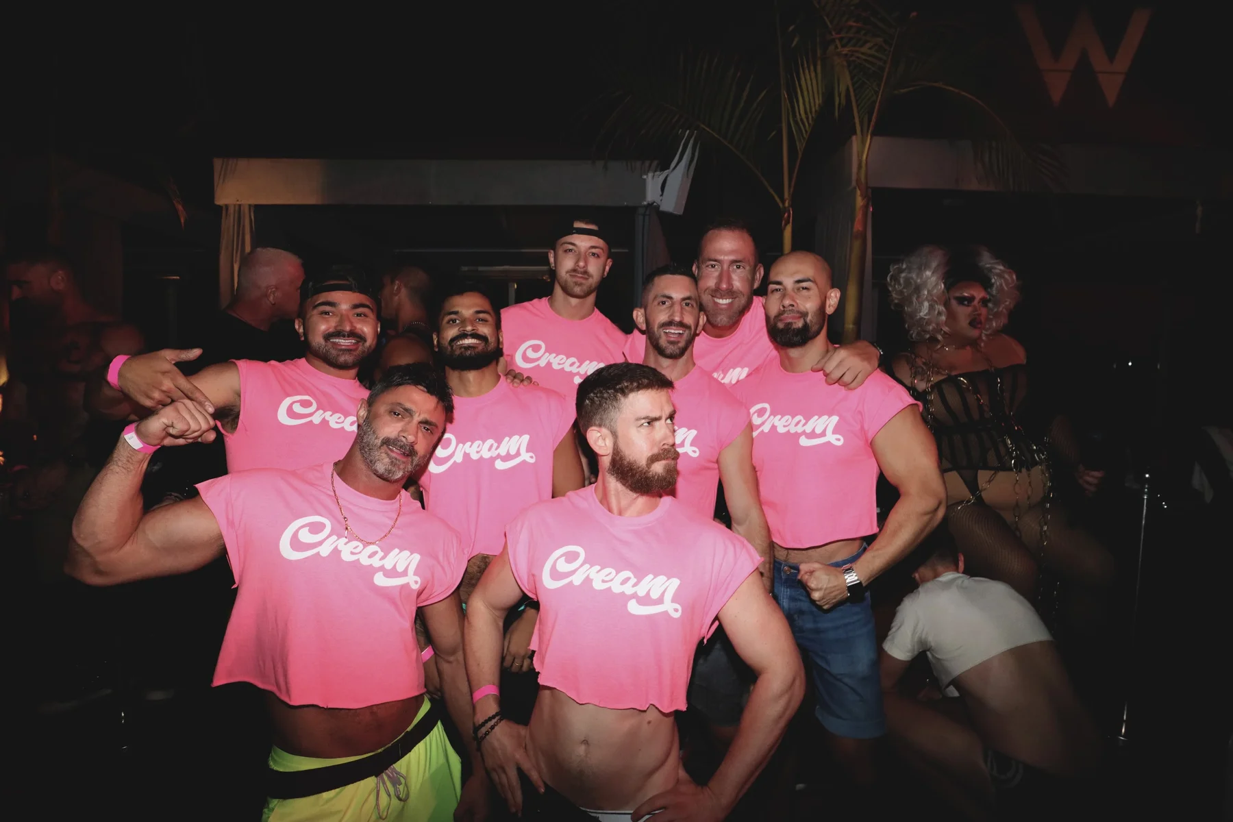 A group wearing pink Cream shirts together at an evening event